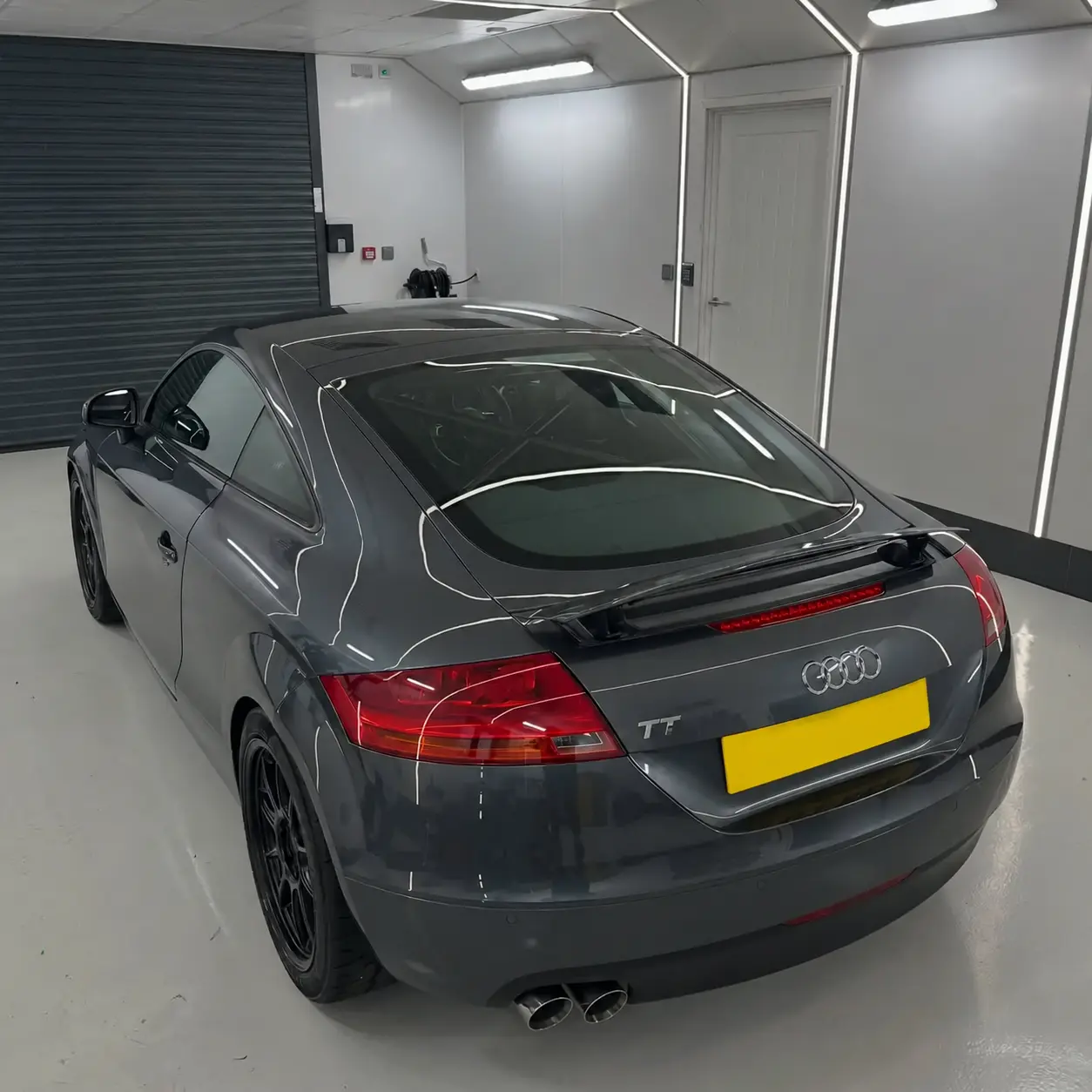 Rear three-quarter view of the Audi TT in the indoor detailing bay