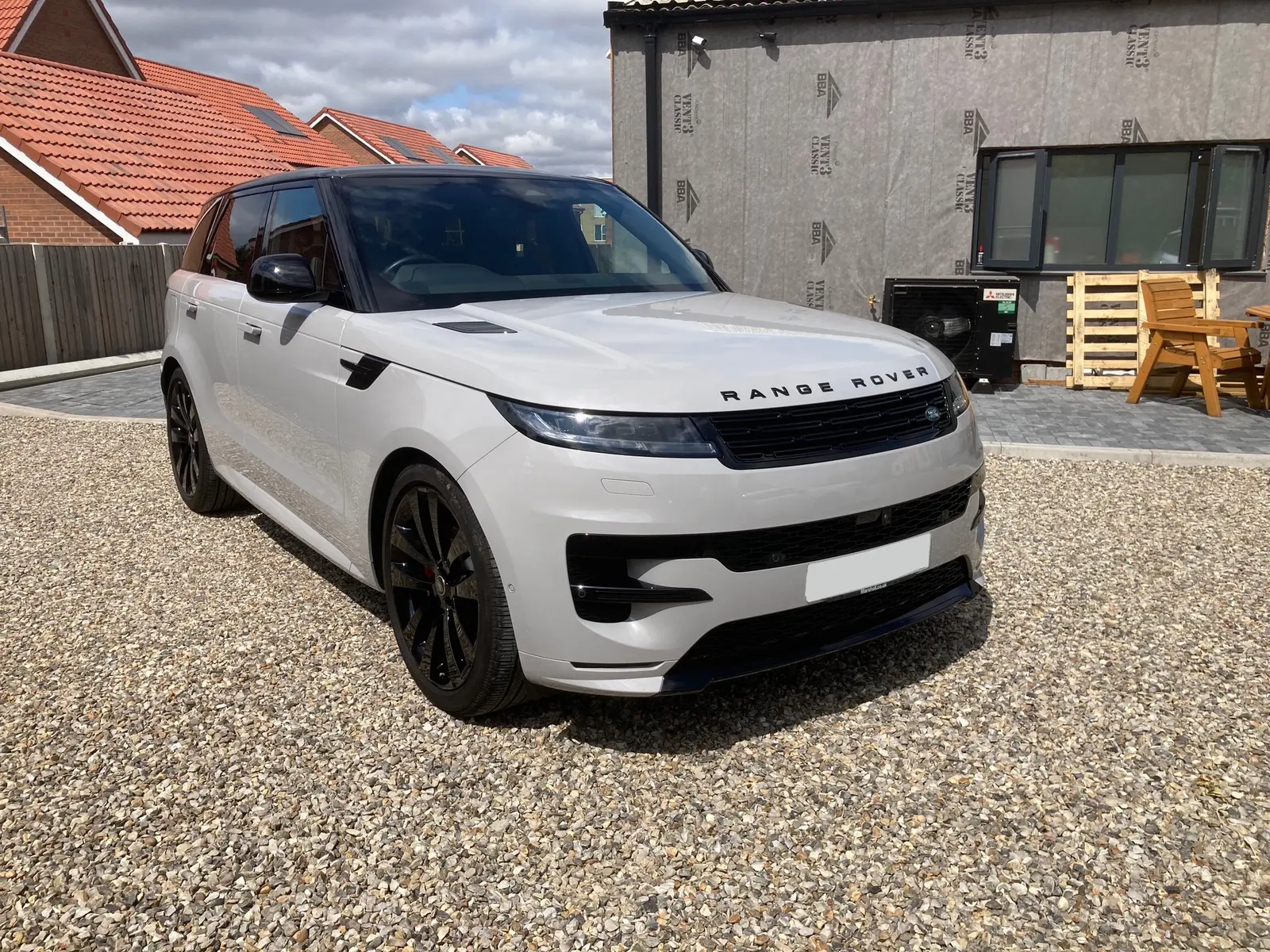 Front three-quarter view showing the Range Rover Sport's pearl paint and coated wheels