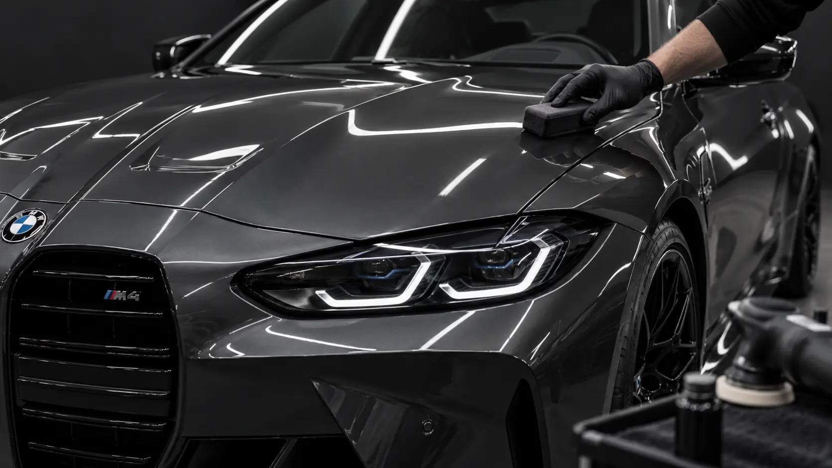 Dark grey BMW M4 receiving ceramic coating after multi-stage paint correction