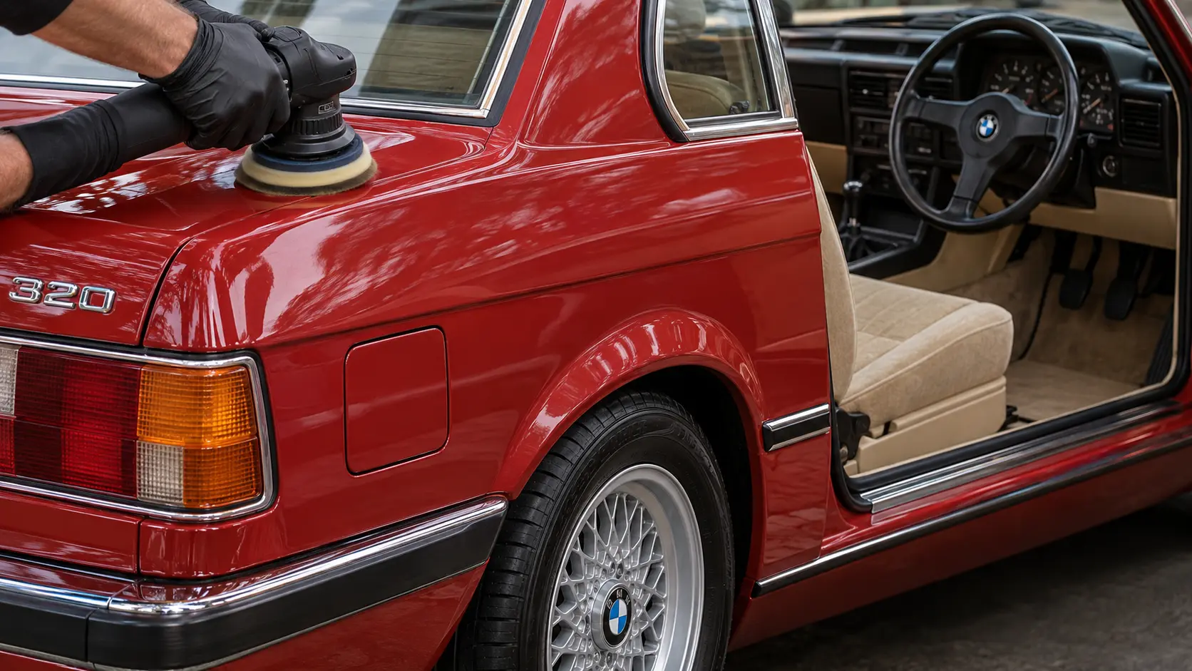 Classic red right-hand-drive BMW E21 receiving paint polishing and a factory restored valet