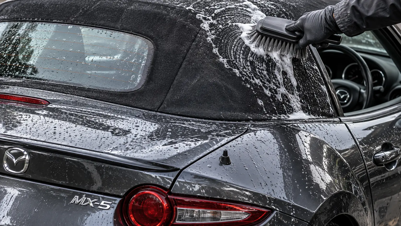 Mazda MX-5 fabric soft top being deep cleaned during an exterior valet
